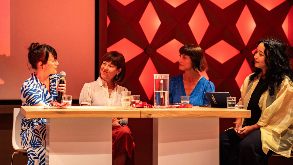 Panel in gesprek op conferentie aan een tafel 