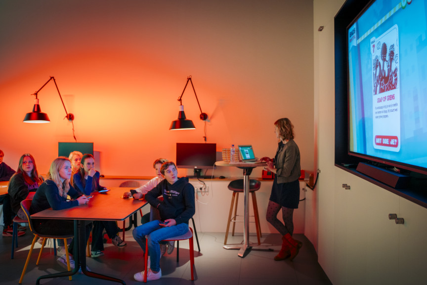 leerlingen luisteren naar beeld en geluid docent tijdens workshop