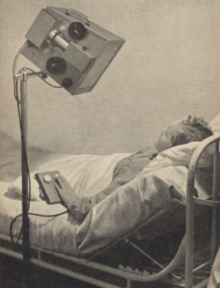 Oude foto van een mens in bed met een lamp boven zich 