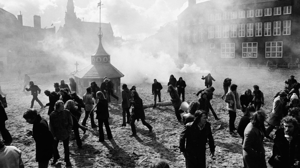 Zwart wit foto van mensen op een plein die door elkaar lopen 