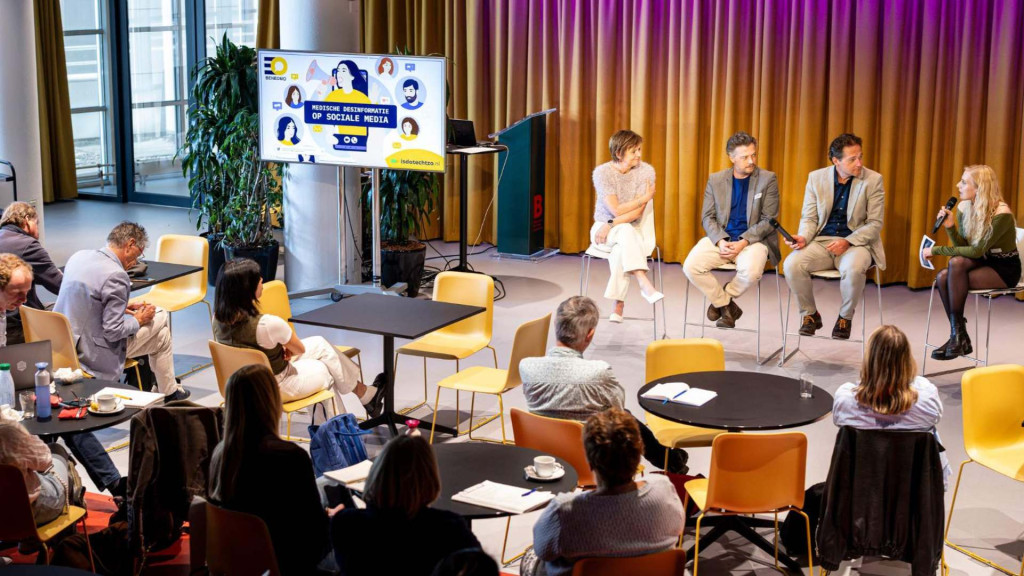 Gezelschap mensen die in een zaal naar een presentatie luisteren