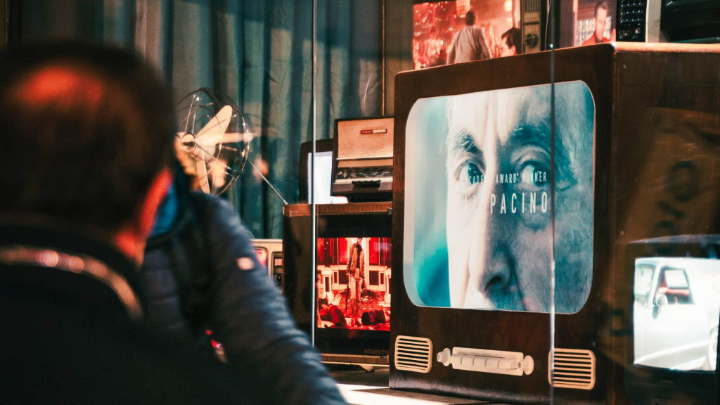 man staat voor een etalage met een tv erin 