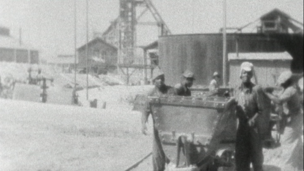 Zwart Wit beeld van mensen aan het werk buiten een fabriek 