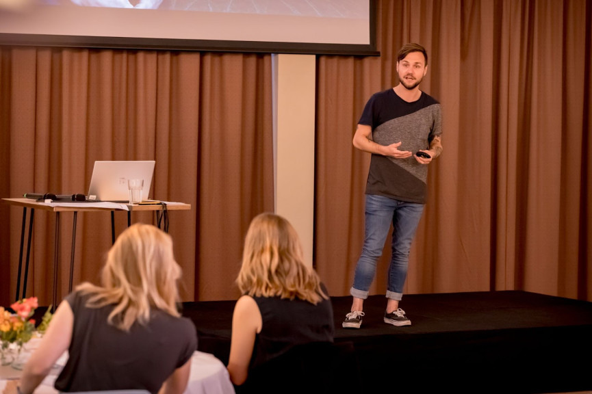 Yordi Dam (ANP) presenteert bij Data als Kans 2021, staand op een podium.