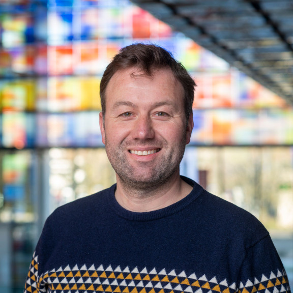 Johan Oomen in front of the coloured glass windows of Sound & Vision