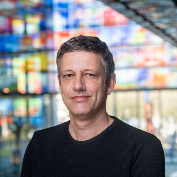 Tjeerd de Boer in front of the coloured glass windows of Sound & Vision