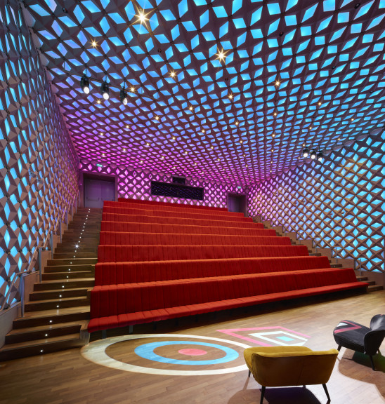 Theaterzaal 1 met vaste bioscoop opstelling in blauw roze licht.