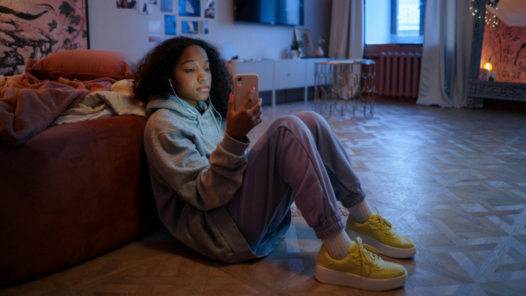 Pesten: Meisje dat sip op haar telefoon kijkt