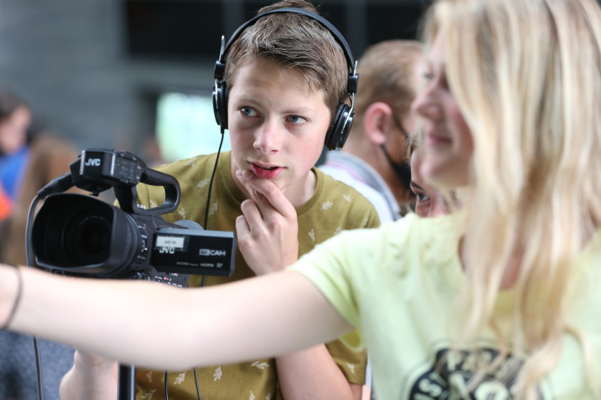 Leerling denkt na terwijl hij achter de camera staat