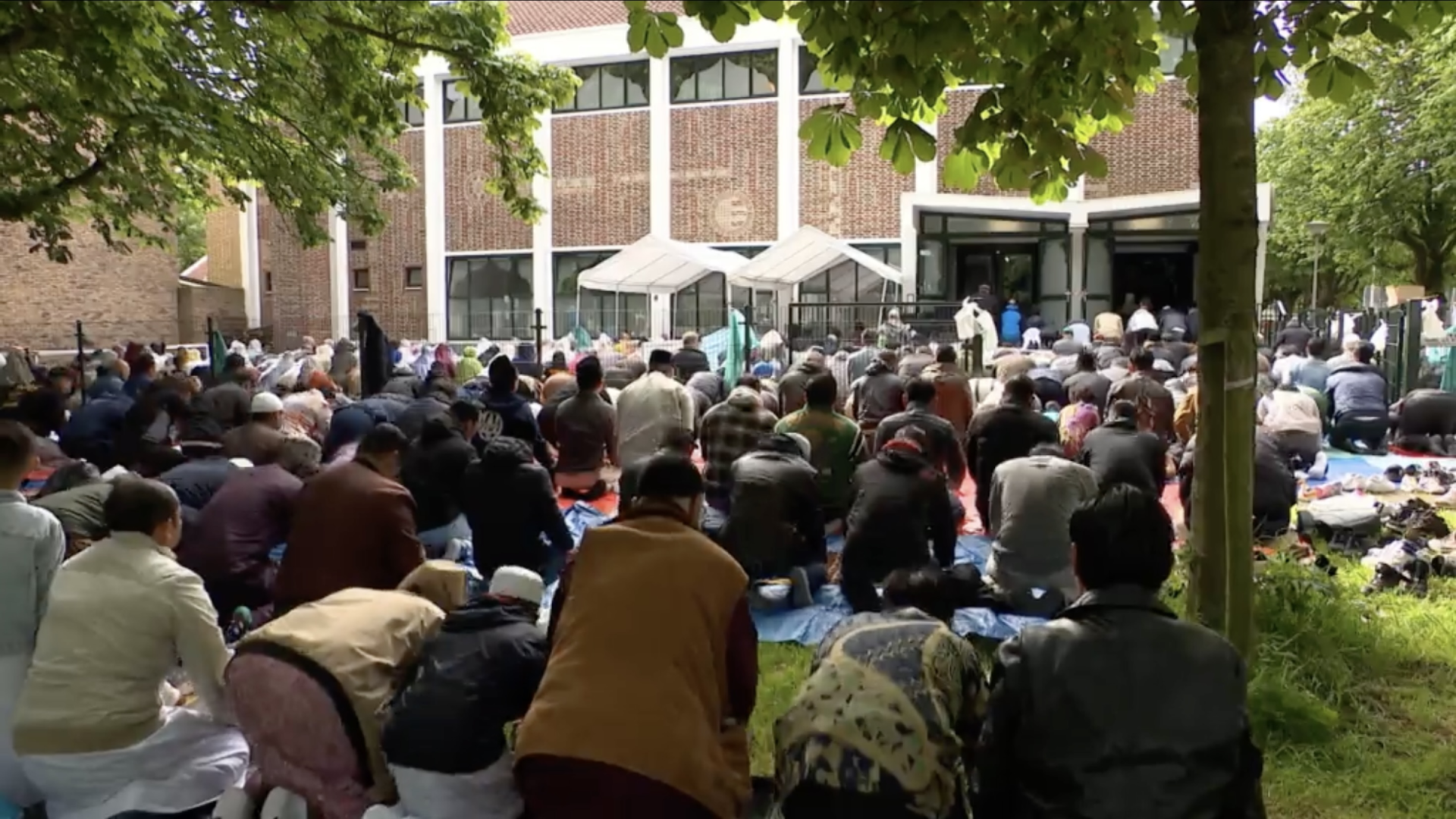 mensen bidden voor de moskee buiten