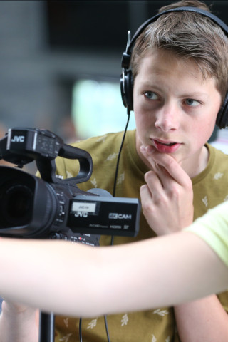 Leerling met camera tijdens workshop newsroom
