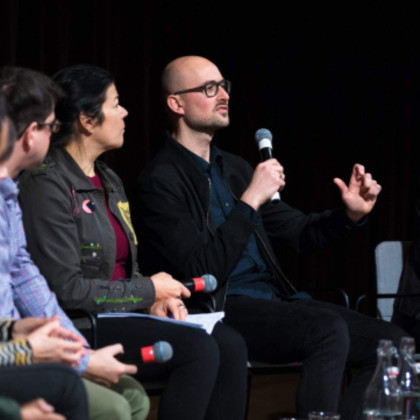 Mensen in gesprek op een podium met microfoon