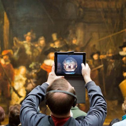 Man maakt met tablet foto van de Nachtwacht