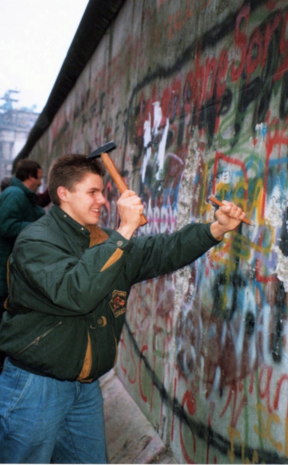 Een man vernield de Berlijnse muur